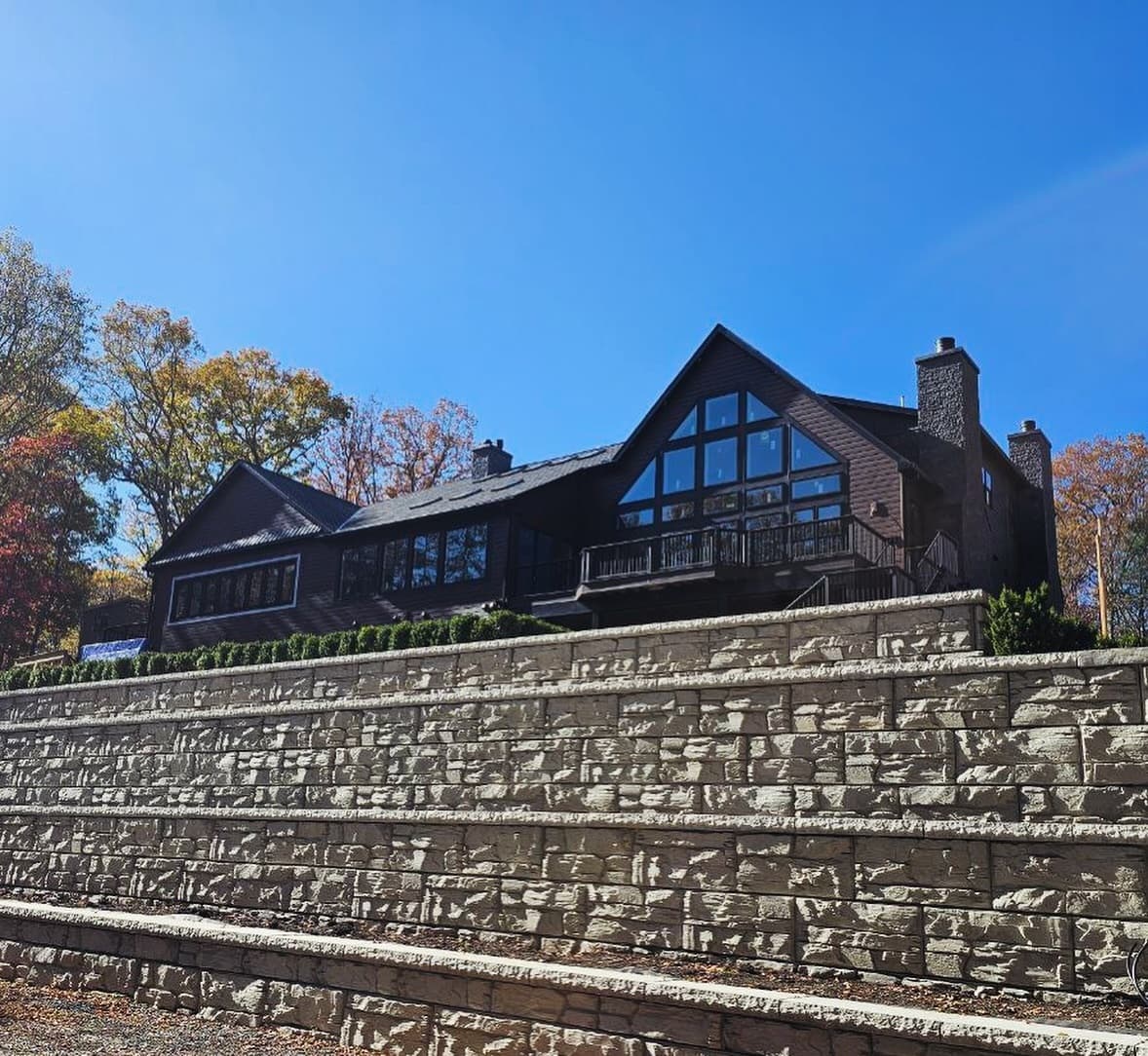 Exterior view across the stone terraces toward the glazed gable