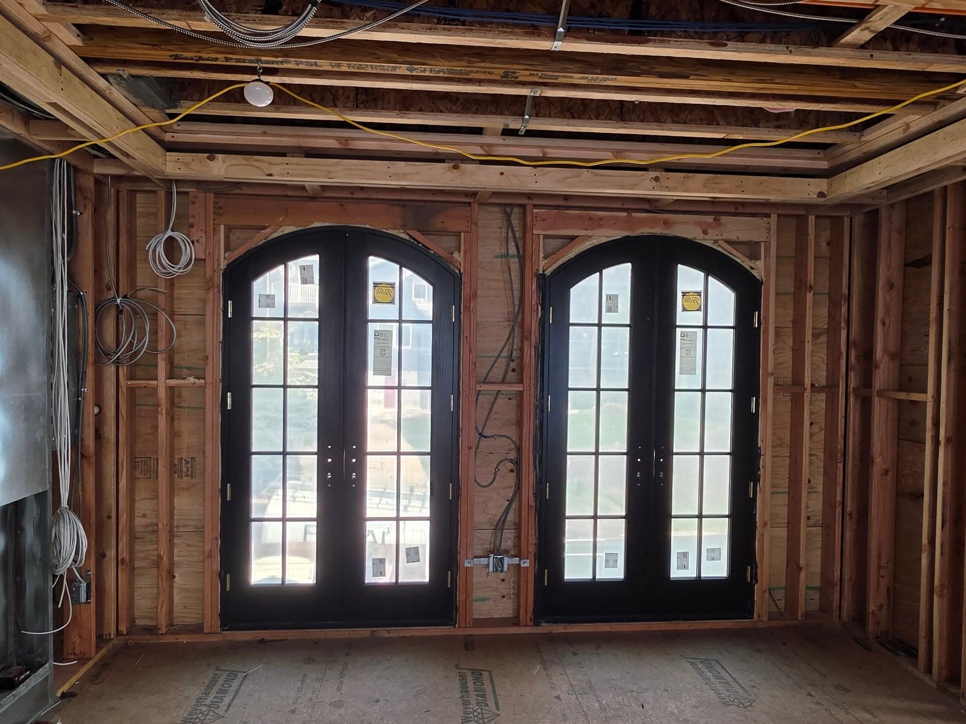 Interior view of paired arched glazed doors during construction