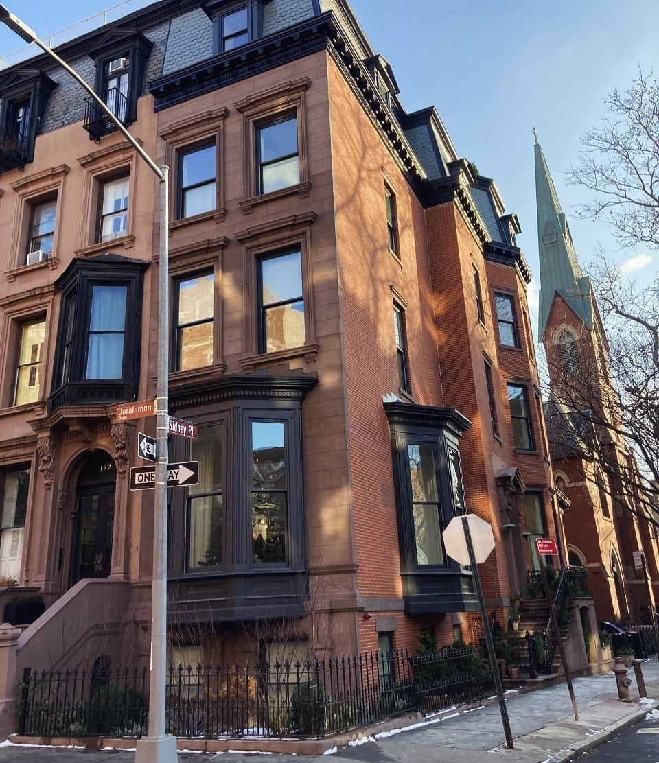 Corner brownstone with tall windows and projecting glazed bays