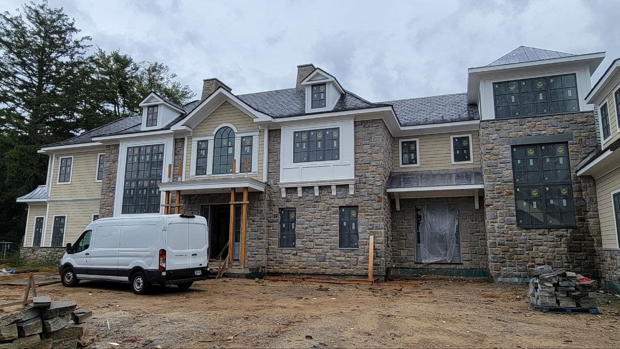 Front elevation during construction with installed dark-framed windows