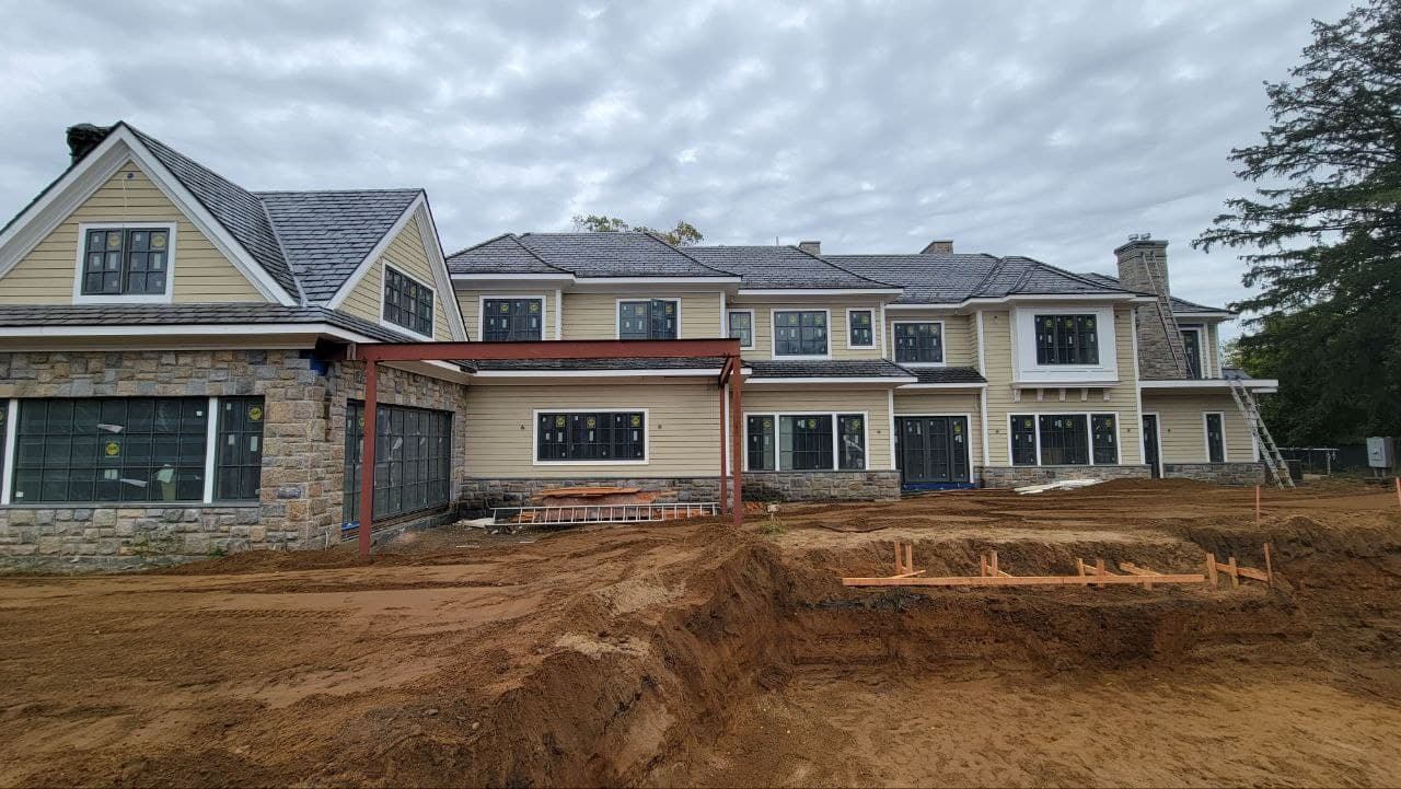 Rear elevation during construction with grouped windows and glazed doors